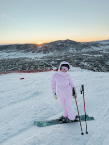 woman in a pink ski outfit on a ski mountain as an example of a trendy ski outfit for 2025/2026
