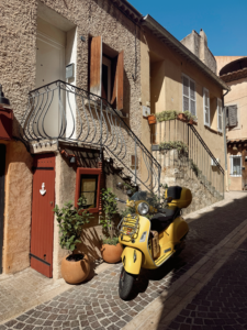 yellow moped parked outside of a French flat in the South of France. Used to create a want to travel the world