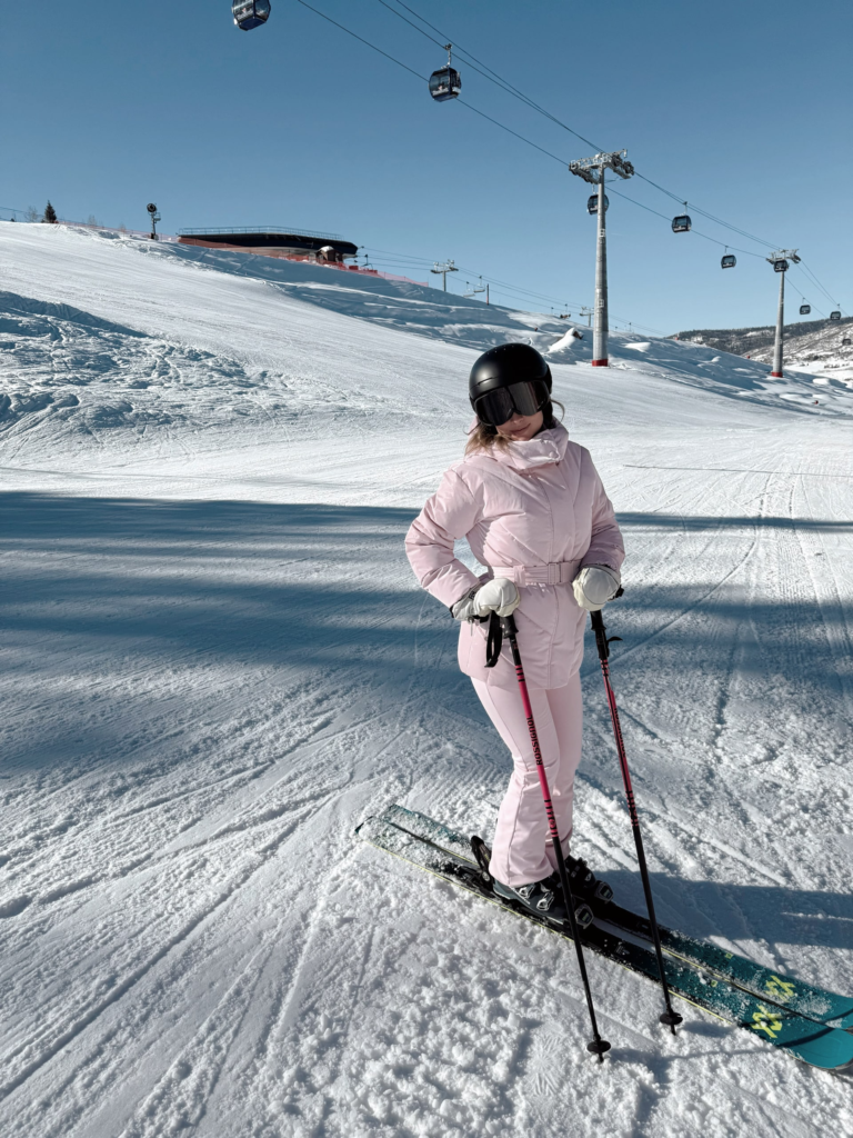 woman in a pink ski outfit on a ski mountain as an example of a trendy ski outfit for 2025/2026