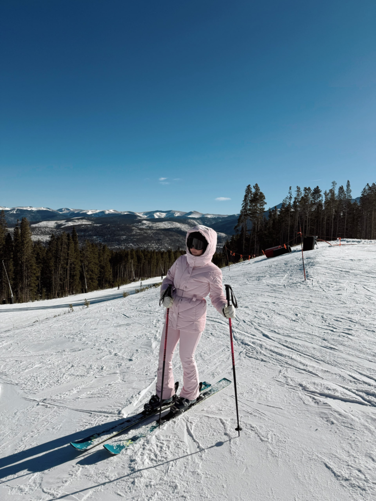 woman in a pink ski outfit skiing in Colorado