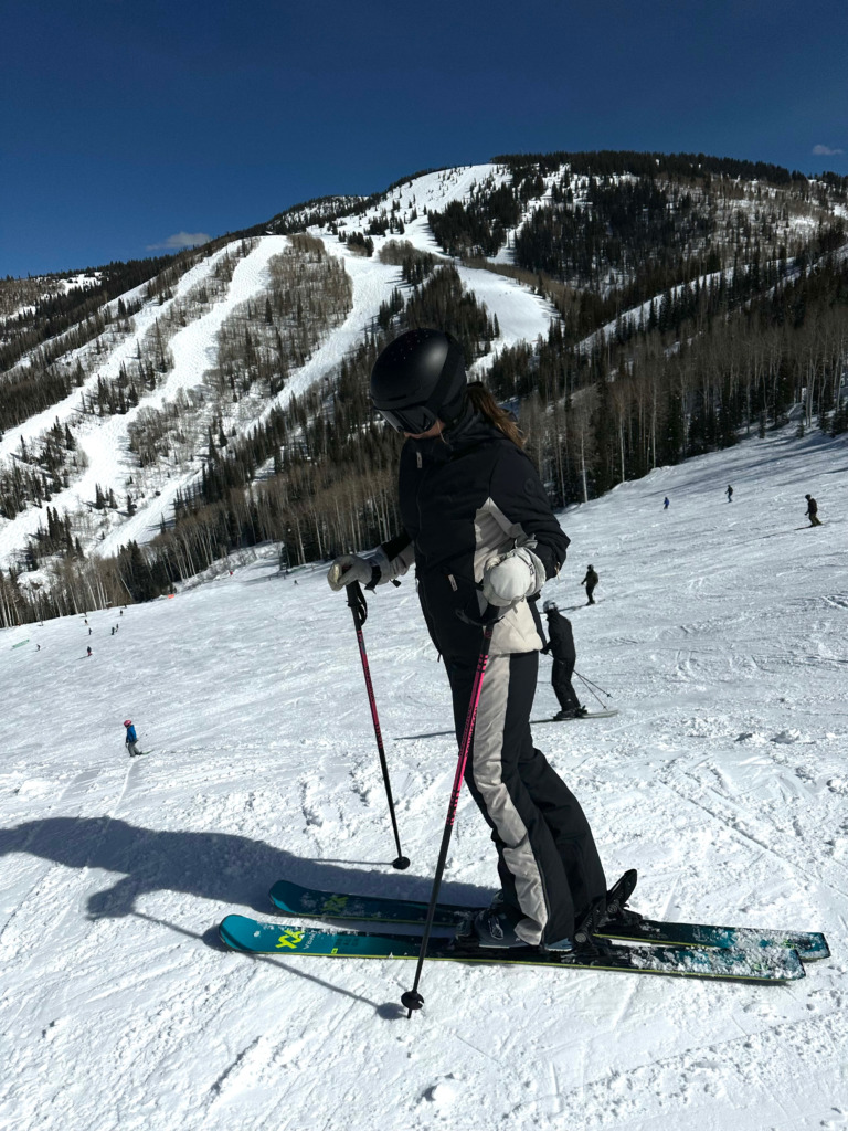 woman in a matching ski set skiing in colorado