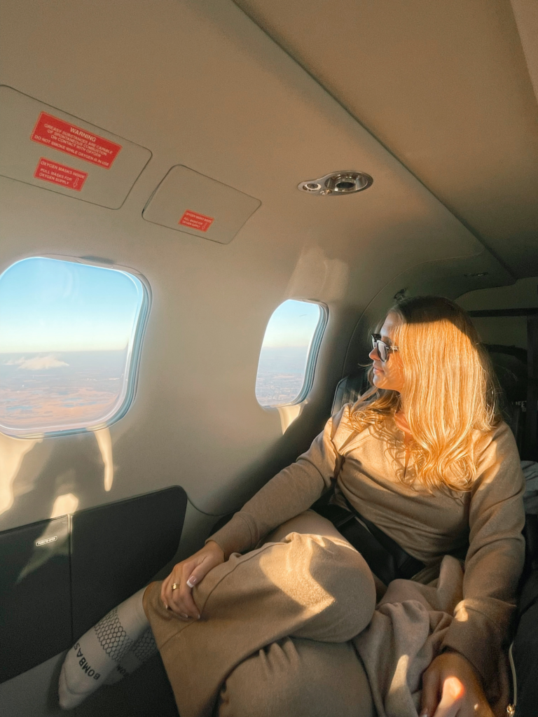 woman looking out the window of a private plane