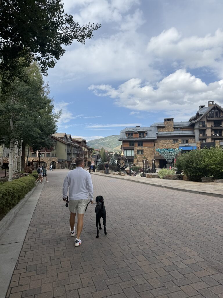 Man walking his black lab in Vail Village, Colorado