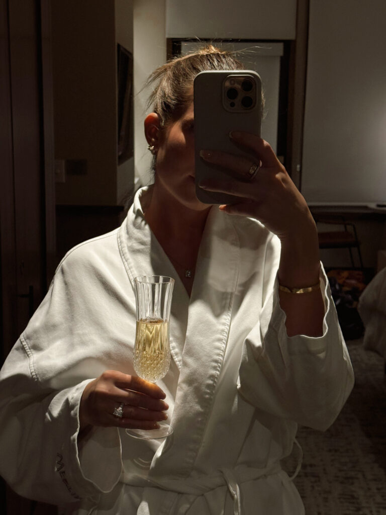 Up close picture of a woman with a champagne glass in a bath robe.